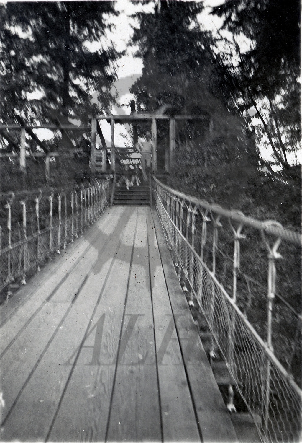 2023.020.009 An unknown man stands at the end of a pedestrian bridge